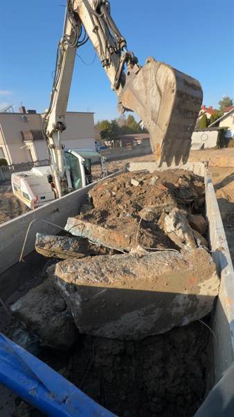 Koparka ładuje gruz betonowy na samochód